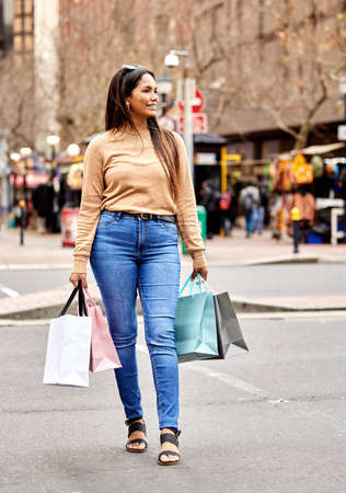 Shes on the lookout for great deals. Full length shot of an attractive young woman carrying a bunch...