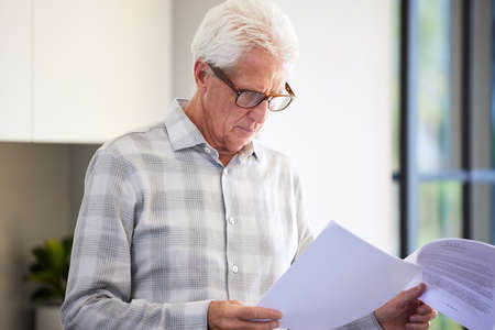I see a few details I want to change. Shot of a mature man reading paperwork.の写真素材