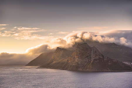 Scenic landscape of mountains along the coast in Hout Bay, Cape Town, South Africa at sunset with cloudy sky and copyspace. Holiday destination for travel and tourism to explore nature and the wildの写真素材