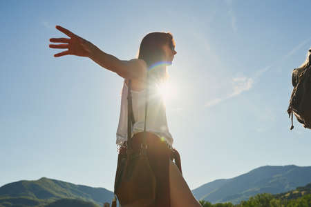 Carefree young woman balancing and walking during a hike in nature with a friend. Young woman enjoying a hike in nature in with a friend. Happy young woman balancing during hike in nature with friendの写真素材