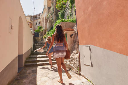 Full length shot of two unrecognisable friends walking through an alley in Amalfiの写真素材