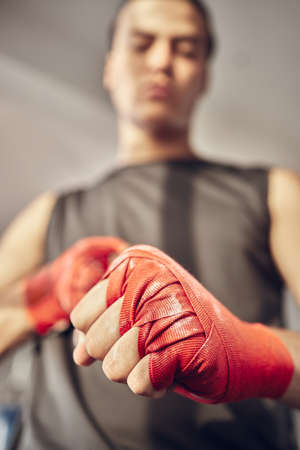 Closeup on hands of boxer with chalk on bandages. Hands of mma fighter ready for combat. Strong athlete with powder on bandage for boxing. Ready to throw a punch. Ready for boxing practiceの写真素材