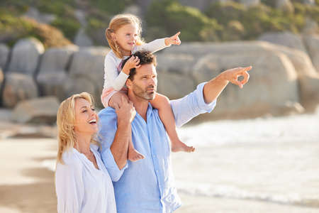 Closeup of a caucasian man spending time at the beach with his cute little daughter and wife. Male...