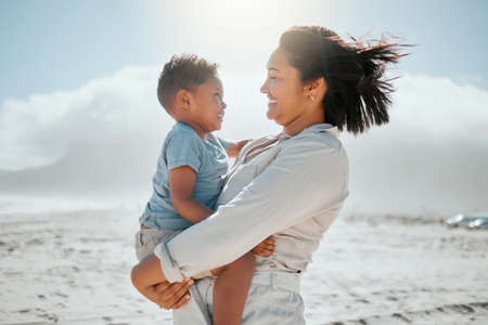 Loving young mixed race mother holding her adorable little son as they looking into each others eyes...