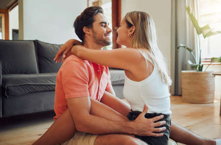Happy caucasian couple being affectionate and enjoying romantic intimate moment while sitting on...