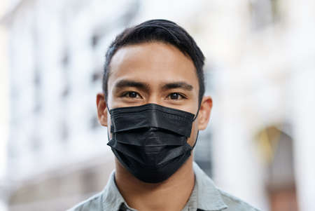 Man wearing a face mask while out in the city.の写真素材