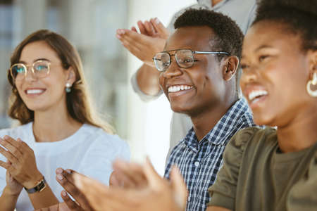 Group of joyful diverse businesspeople clapping hands in support during a meeting together at work....
