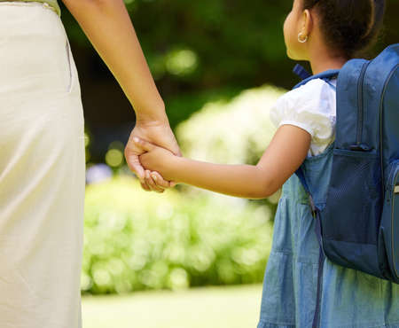 Having a wonderful family like mine is truly a blessing. Cropped shot of a little girl holding her mothers hand while walking outside.の写真素材