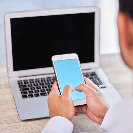 Closeup hand of businessman using smartphone. Businessman typing on blue blank screen mobile phone...