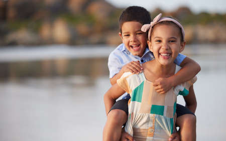 The stem to her flower. Shot of an adorable brother and sister bonding at the beach.の写真素材
