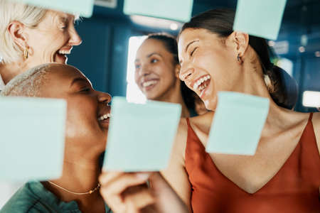 Theyve got the plan. Cropped shot of an attractive and diverse group of businesswomen working with sticky notes on a glass wipe board in the boardroom.の写真素材