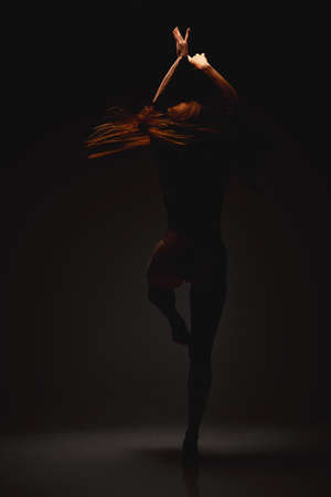 Souls relief. Shot of a performer dancing against a dark background.の写真素材
