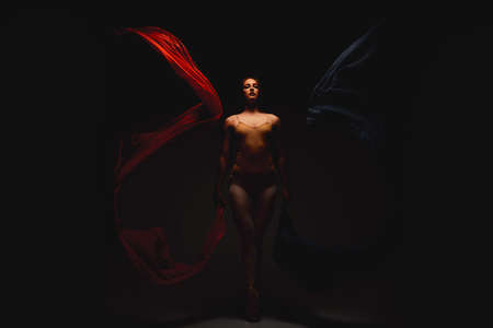 She emanates magic. Shot of a performer dancing against a dark background.
