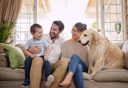 In my family, crazy is relative. All of them. Shot of a young family sitting on the living room sofa...