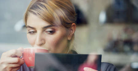 Working in her favourite coffee shop. Cropped shot of an attractive young businesswoman working in a...