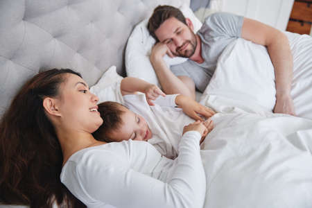 Daily nap time. Shot of a young family relaxing at home.の写真素材