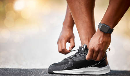 A increasing lack of fitness, is a menace to health. Shot of a unrecognizable man tying his...