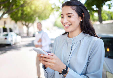 Shot of a young businesswoman using a cellphone in the city.