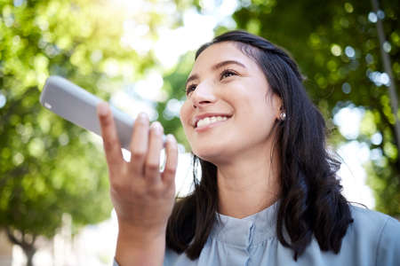 Low angle shot of a young businesswoman using a cellphone in the city.