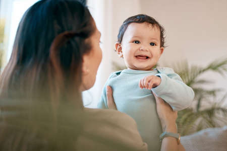 Motherhood All love begins and ends there. Shot of a young mother bonding with her adorable baby at home.の写真素材