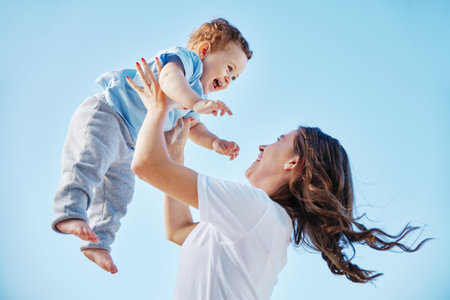 She promised to raise him right. Cropped shot of an attractive young woman and her adorable baby boy playing outside.の写真素材