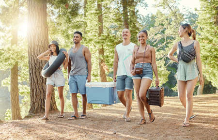 Where should we set up. Full length shot of a diverse group of friends enjoying a day out in the woods.の写真素材