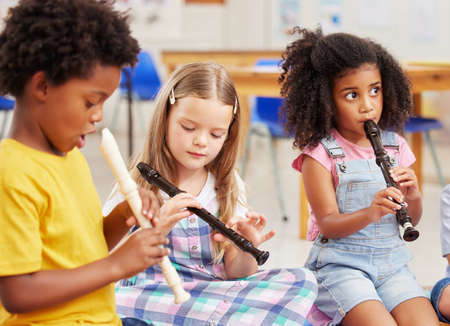 The flute is our favourite instrument. Shot of children learning about musical instruments in class.の写真素材