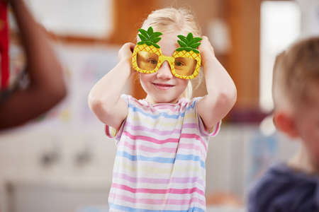Pineapples are my favourite. Shot of a little girl wearing funky glasses in class.の写真素材