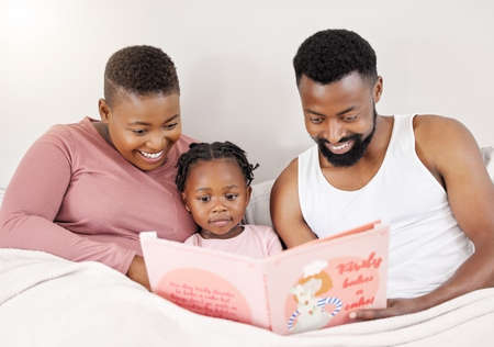 We believe she is our higher purpose. Shot of a young family bonding in bed together.
