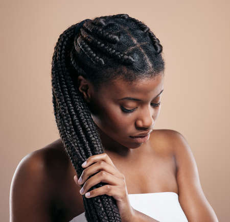 Strong hair doesnt let go. Cropped shot of an attractive young woman posing in studio against a...