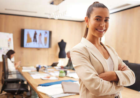 A leader in design. Shot of a young businesswoman standing with her arms crossed in an office at work.の写真素材