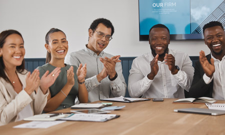 A group of young diverse and confident corporate business people clapping while sitting in the boardroom during a work meeting. Celebrating the success and promotion of a coworker. Were happy for youの写真素材
