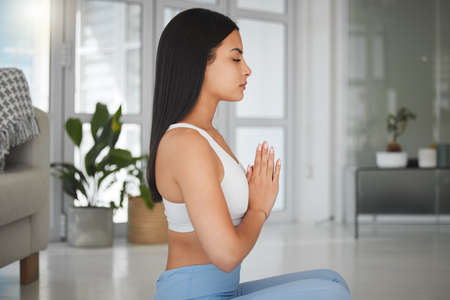 Learn to be calm within yourself. Shot of a sporty young woman meditating while practising yoga at...