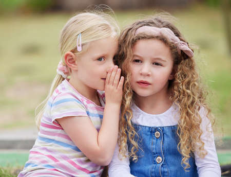 Dont tell anyone that I told you. Shot of a little girl whispering in her friends ear.