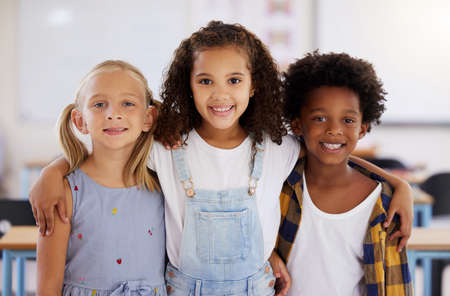 Shot of three preschool students standing together in class.の写真素材