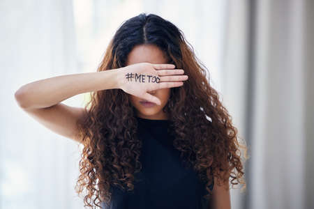 Shot of an unrecognisable woman with the hashtag me too written on her hand.
