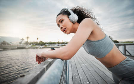 Cropped shot of an attractive young female athlete taking a break during her morning run outside.の写真素材