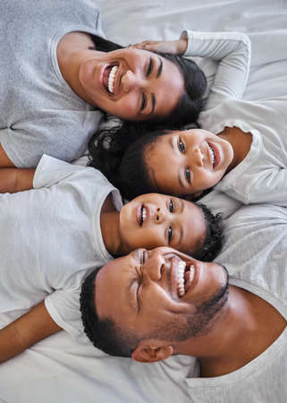Shot of a beautiful young family bonding in bed together.