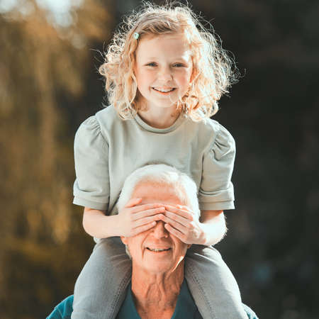Little girls are the nicest things that happen to people. Shot of a girl being carried by her grandfather outside.
