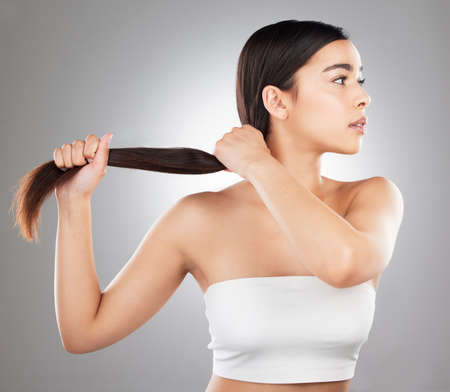 Ooh, shes thick. Studio shot of a beautiful young woman showing off her long silky hair against a...