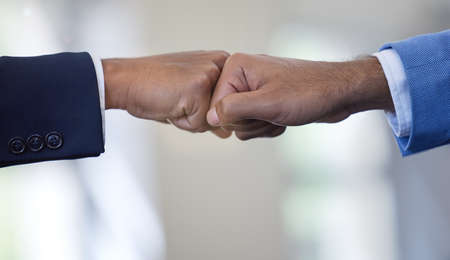 Weve got this. Closeup shot of two unrecognisable businessmen giving each other a fist bump in an office.の写真素材