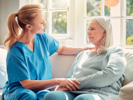Leaders need to be facilitators. Shot of a senior woman being supported by her nurse at home.の写真素材