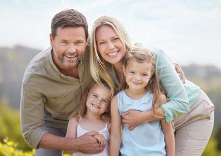 Family members can be your best friends. Shot of a couple and their two daughters posing together in a park.の写真素材