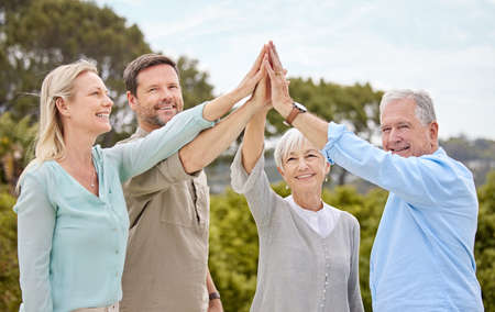 Rejoice with your family in the beautiful land. Shot of a family giving each other a high five in...