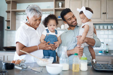 Were learning grandmas secret recipe. Shot of a woman baking in the kitchen with her son and two grandchildren.の写真素材