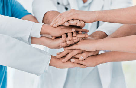 Improving patient outcomes together. Closeup shot of a group of medical practitioners joining their...