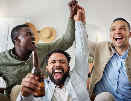 Shot of three male friends looking cheerful while drinking beers and sitting together.の写真素材