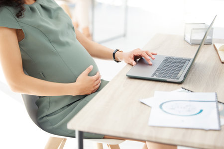 Sorting all her tasks before maternity leave. Closeup shot of a pregnant businesswoman working on a laptop in an office.の写真素材