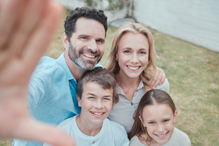 Say family. Shot of a family taking a selfie in the garden at home.の写真素材