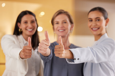 Believe in your capability to succeed big. Closeup shot of a group of businesswomen showing thumbs up together in an office.の写真素材